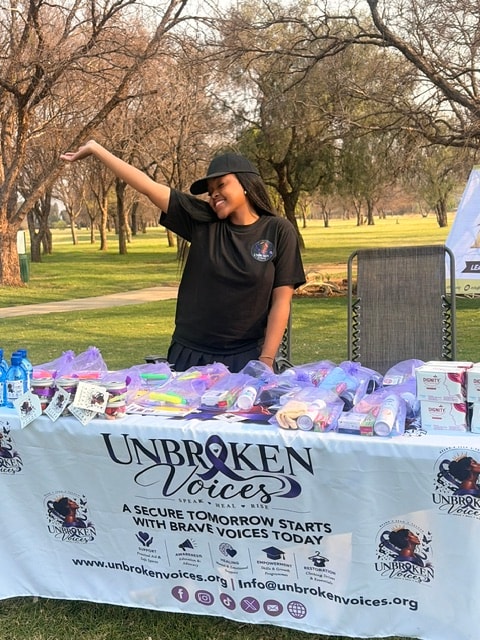 Omphemetse Sisanda Mthembu at an Unbroken Voices community outreach table