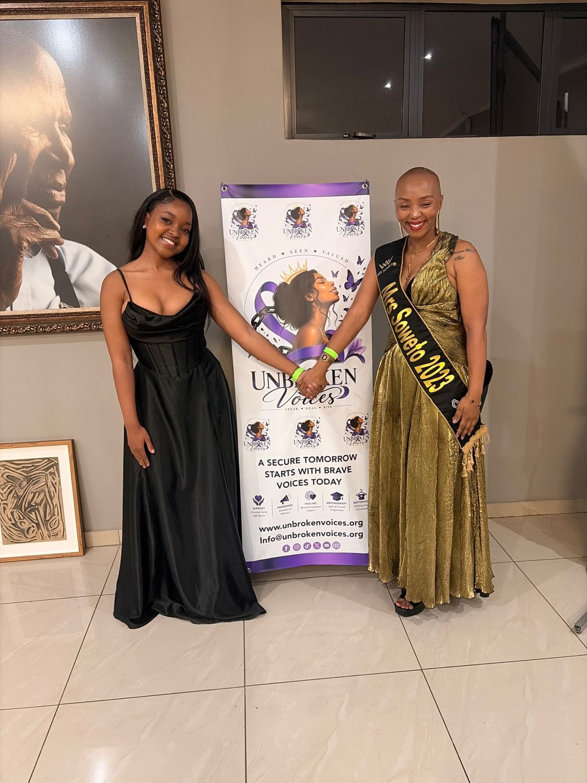 Unbroken Voices founder with Mrs Soweto 2023 beside the organisation banner